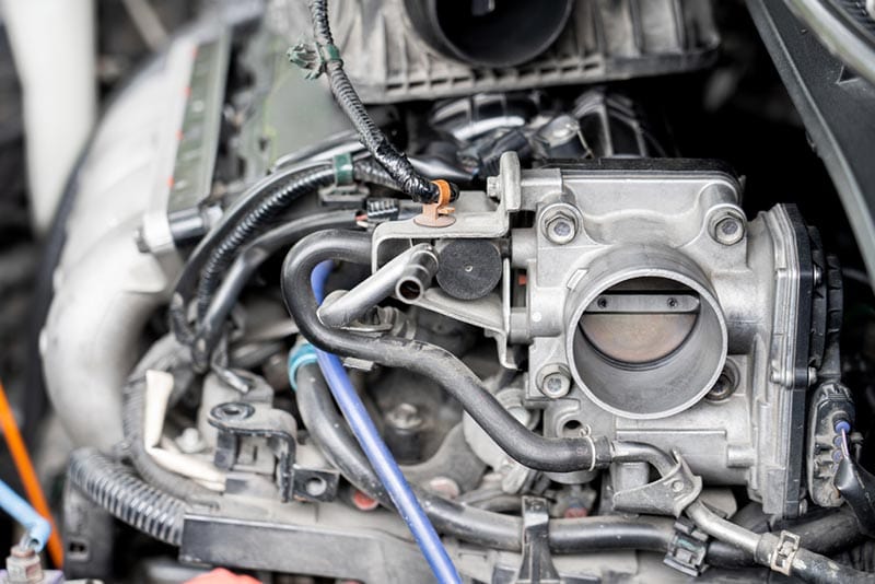 close up of old throttle body of car in engine room