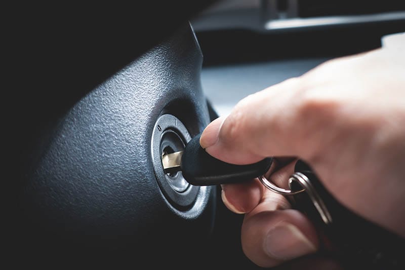 hand turning car key to start the car