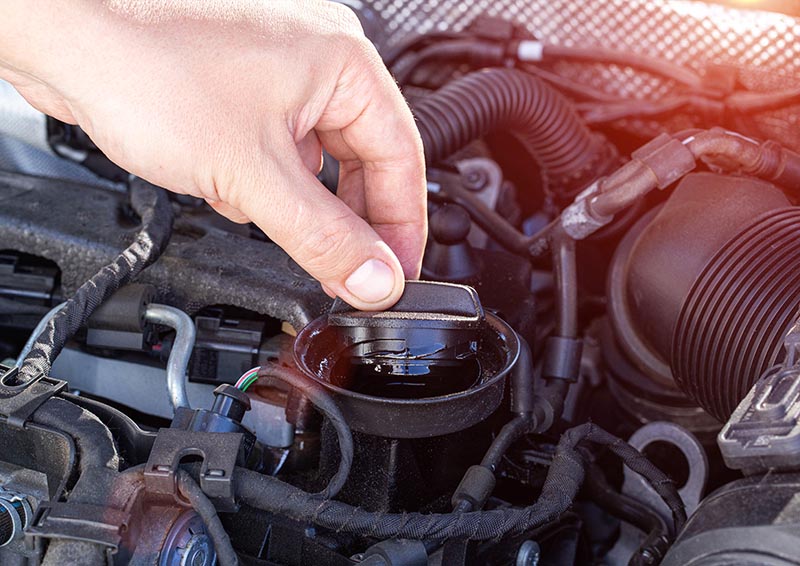 hand unscrews oil filler plug of diesel engine