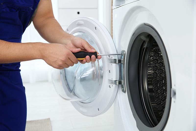 handyman fixing dryer door