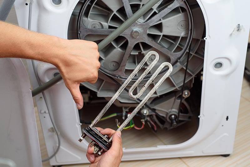 handyman repairing the back part of a dryer