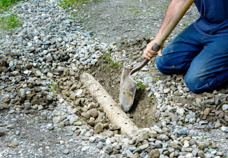 man digging french drain