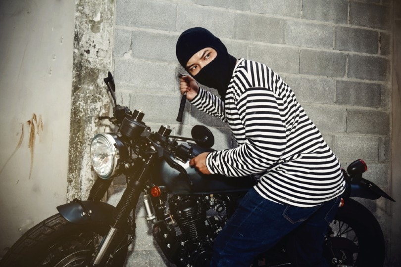 man trying to steal a motorcycle