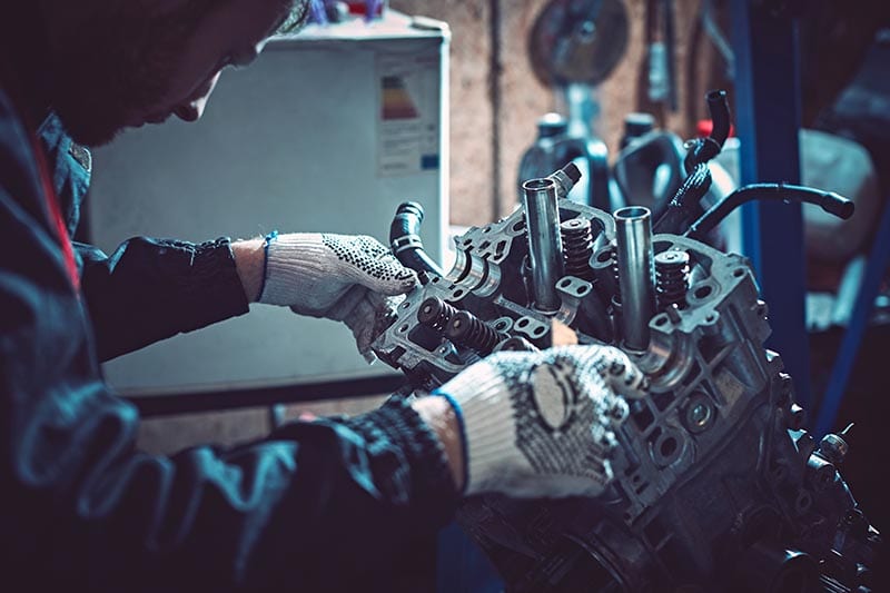 mechanic checking the dismantled diesel engine