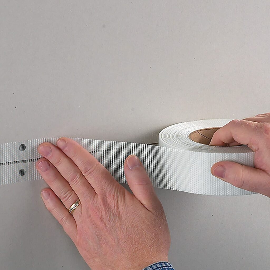 person applying FibaTape FDW8654-U Perfect Finish, Ultra-Thin Joint Drywall Tape on the wall