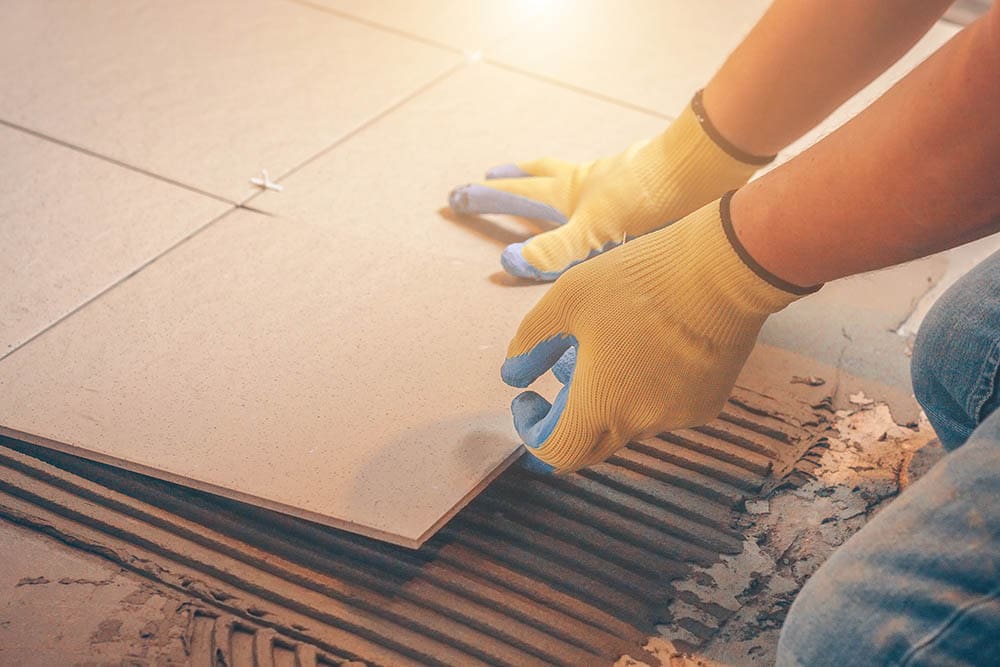 person installing rectified tiles