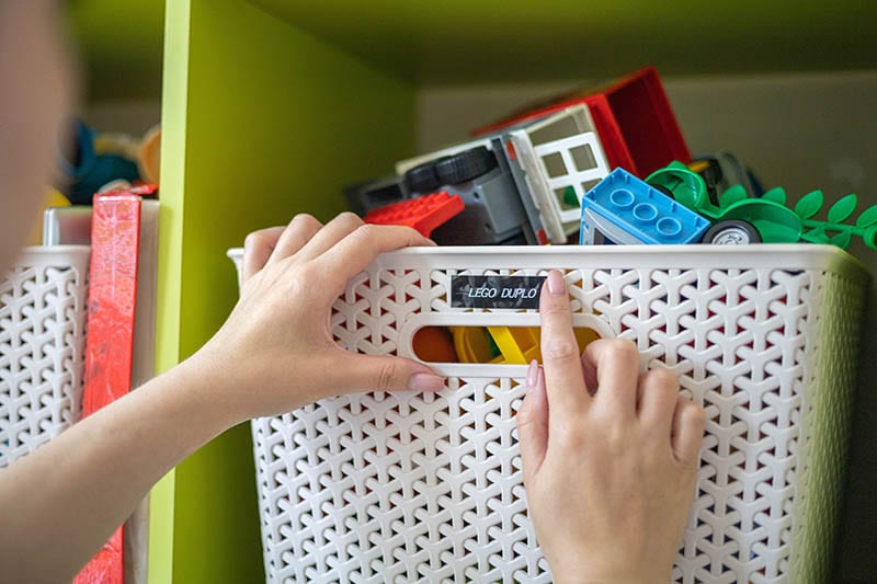 person sticking label on plastic box