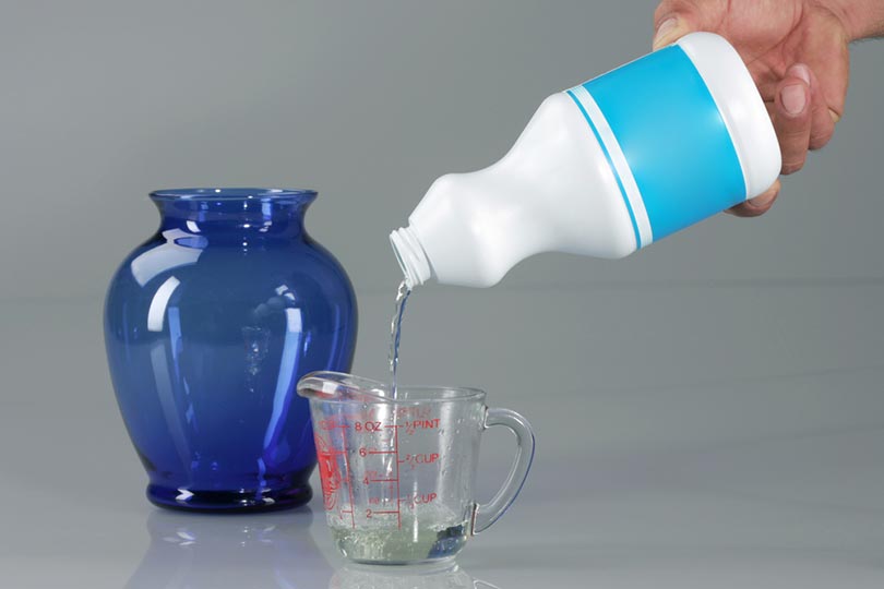 pouring bleach in measuring cup