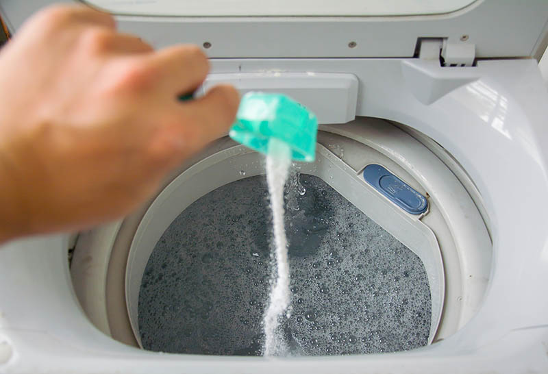 pouring baking soda into washing machine