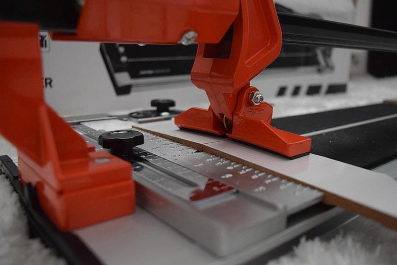 tile cutter cuts through ceramic tile