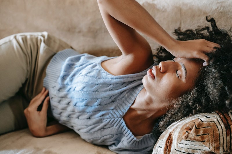 woman on the couch with a headache