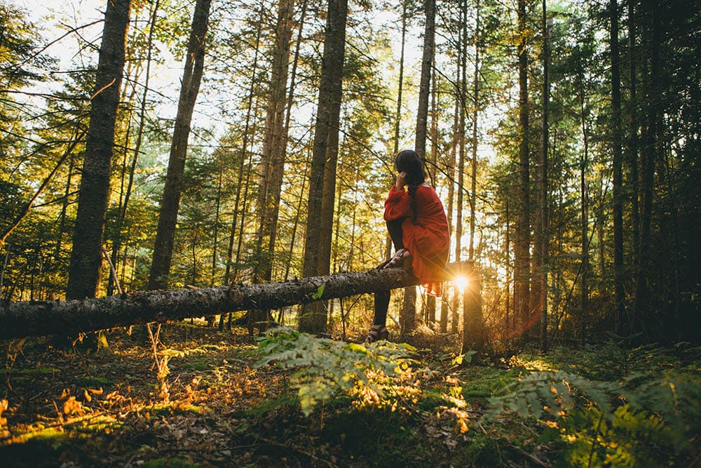 woman sitting outside of the woods