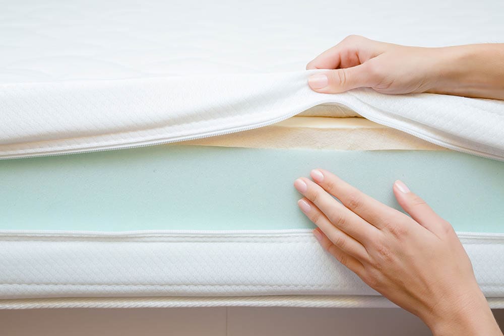 woman touching different layers of a mattress