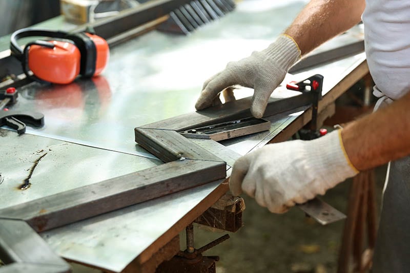 worker making metal bowstring for stairs