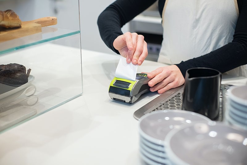 An Employee Using a Payment Terminal printing receipt