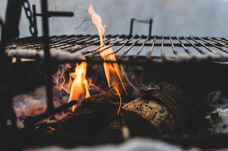 Burning under black metal grill