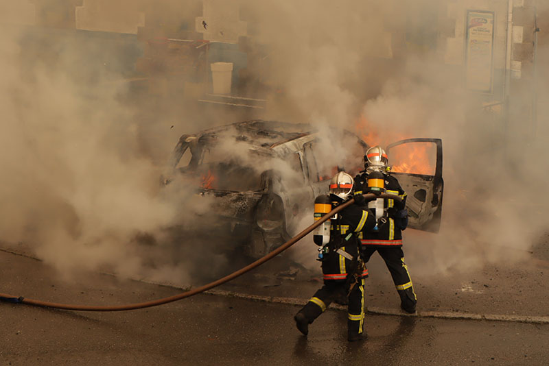 Car on fire and firemen