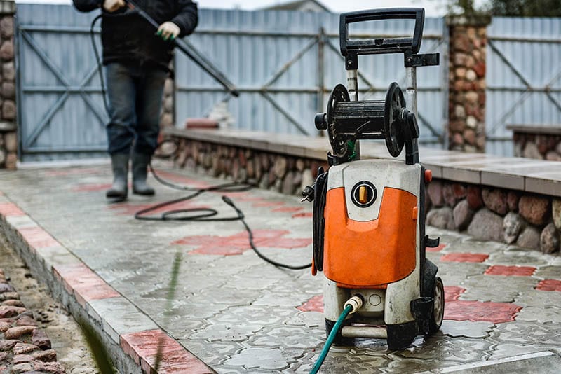 Cleaning paving slab using high pressure power washer