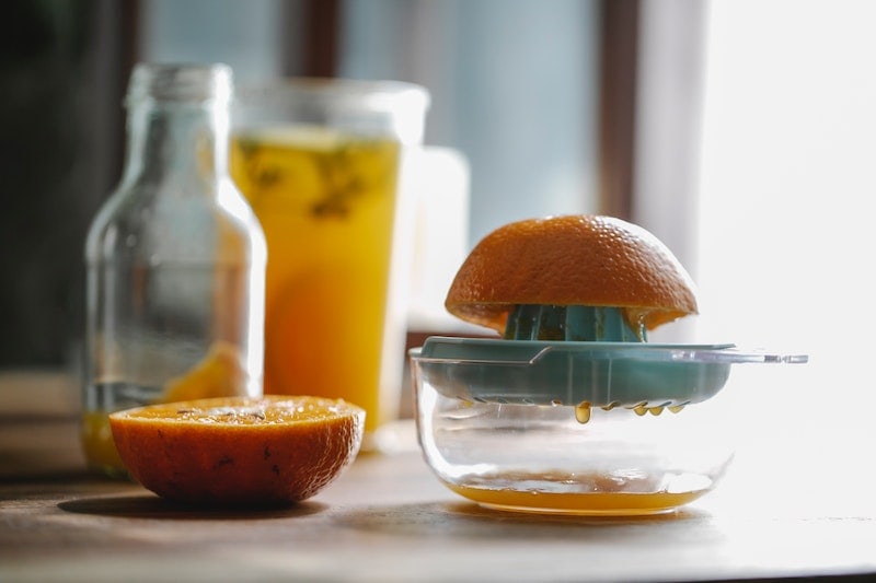 Cut ripe orange placed on juicer