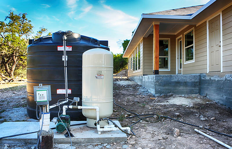Deep water well set up in front of new home construction