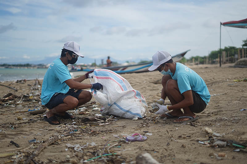 Indonesian males cleaning the beach