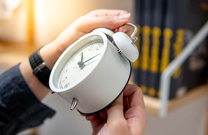 Male hand adjusting or changing the time on white