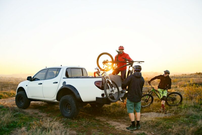 Men Taking the Bicycles off the Pickup Offroad Truck