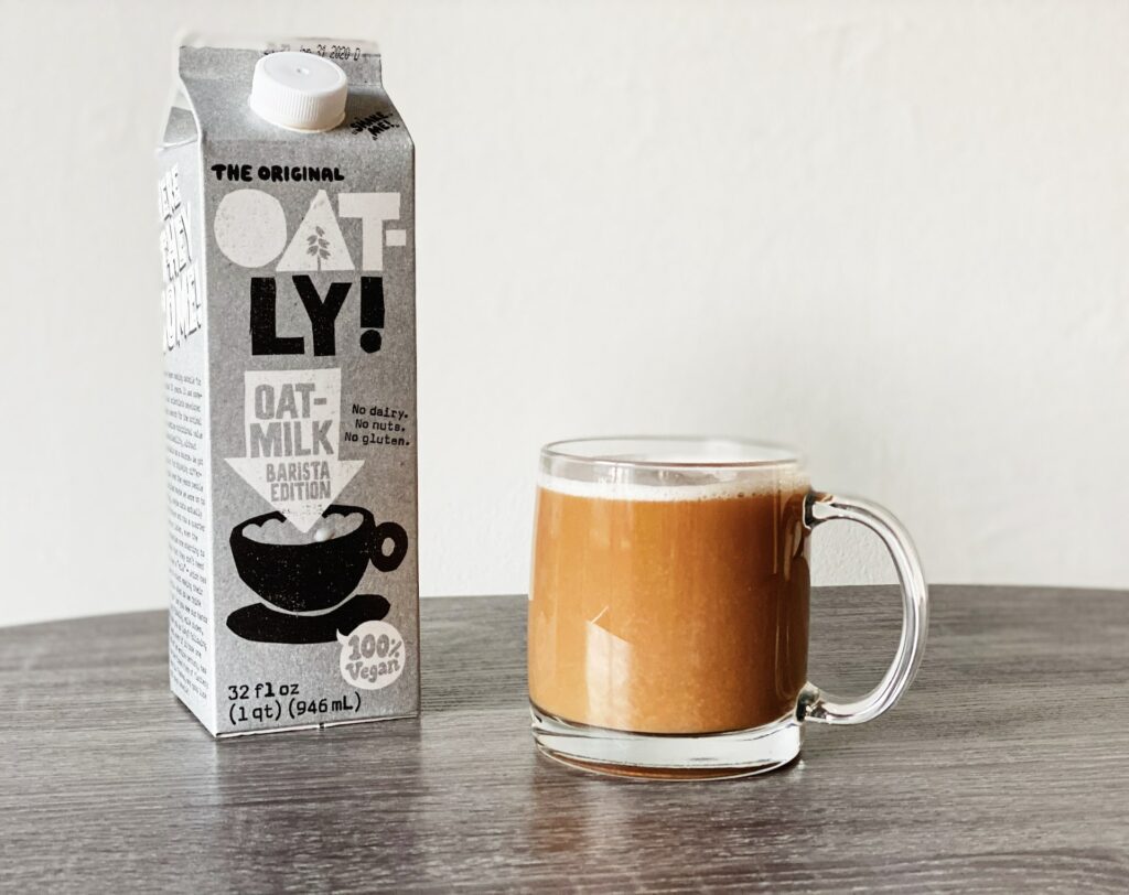 Milk carton beside a cup of coffee