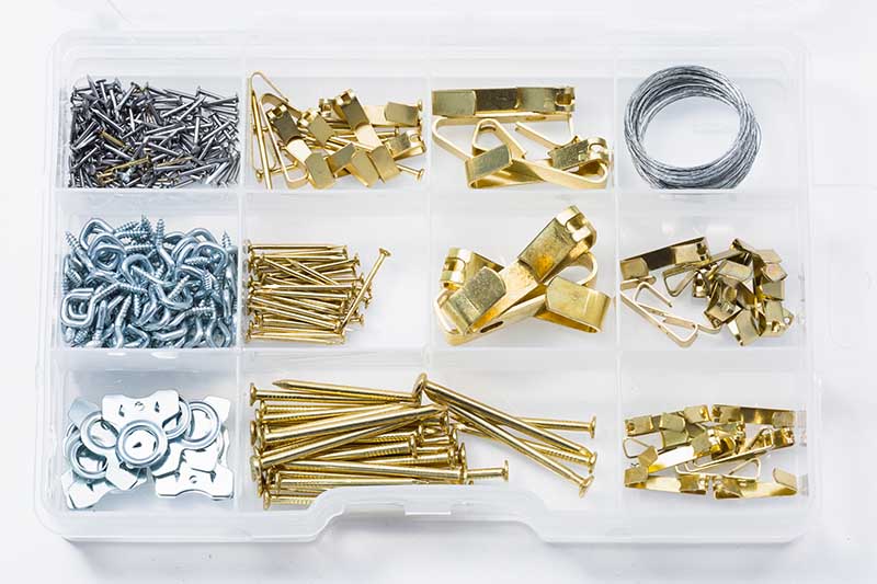 Organized picture hanging hardware kit with nails, screws, hooks, and wire