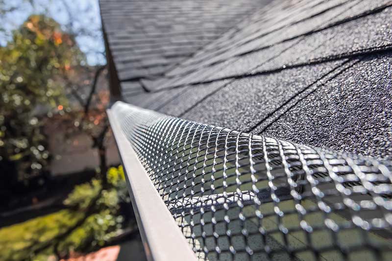 Plastic guard over gutter on a roof