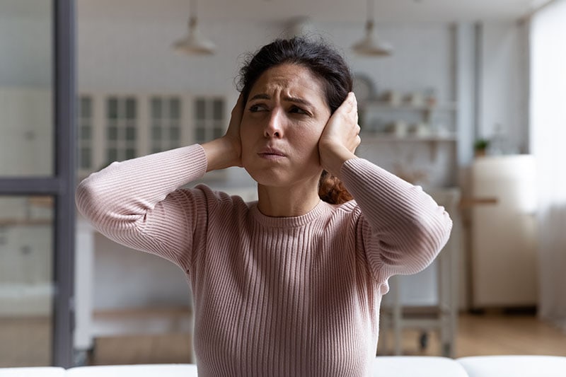Tenant cover ears with hands hate noise at home