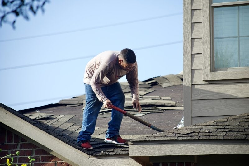 a repairman tearing the roof apart