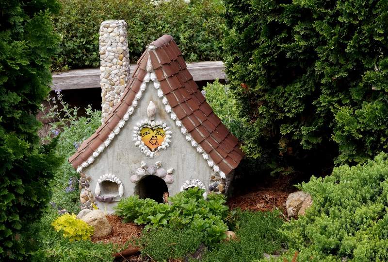 a toad house surrounded by grass and plants