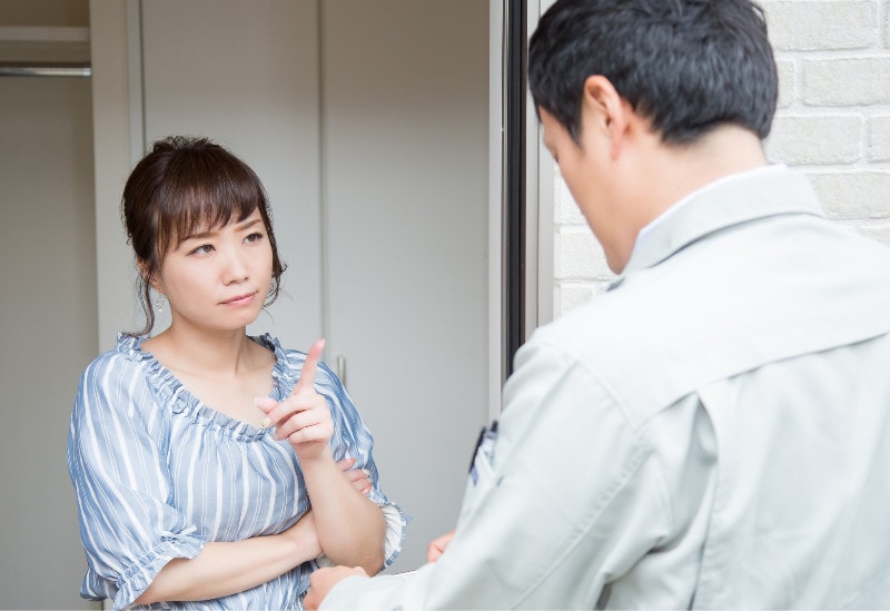 a woman looking skeptically at a door salesman