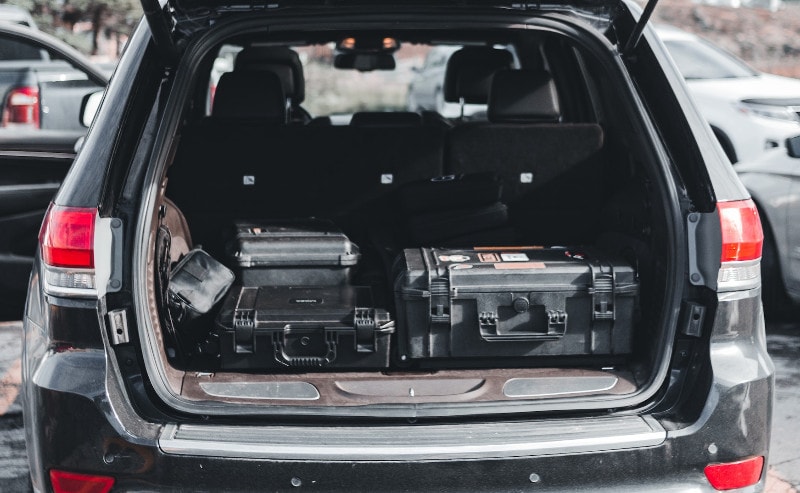 an open trunk of a car with black organizer storage cases