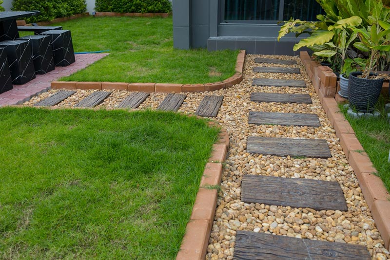 backyard garden path with river stones mulch