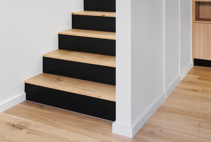 black and brown indoor wood stairs and floor adjacent white walls