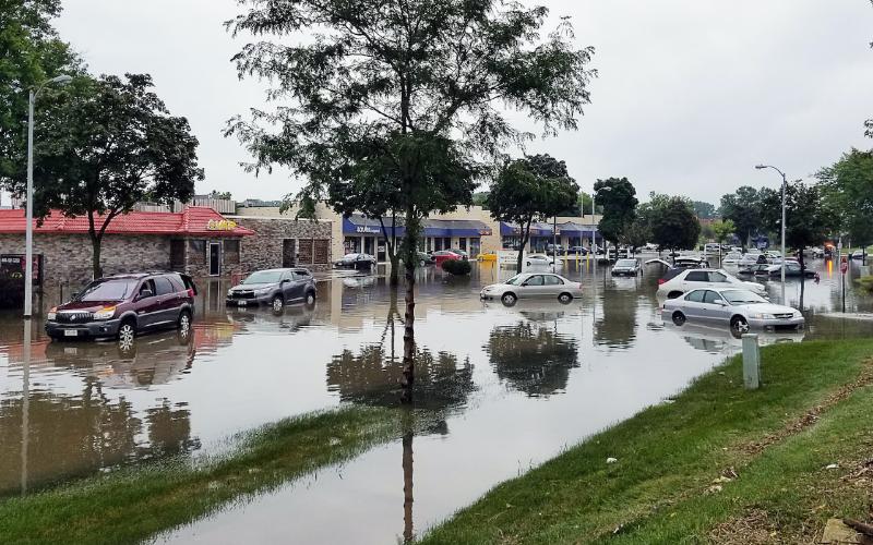 cars in parking lot submerged in flood water