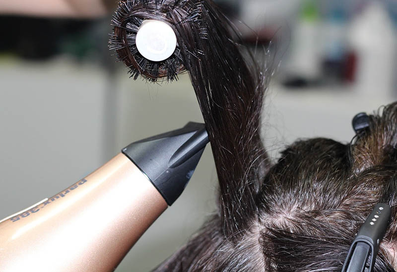 close up drying hair with dryer and brush