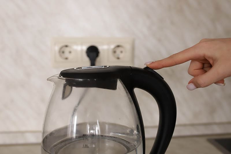 finger switching on electric kettle