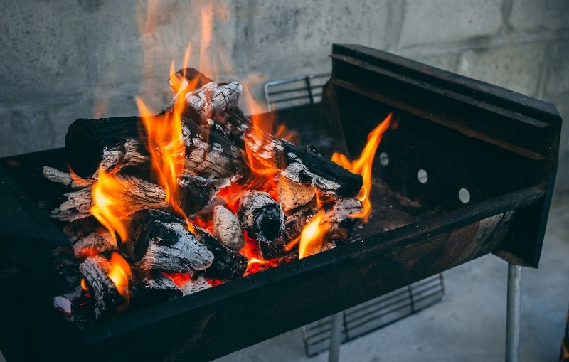 flaming charcoal on an open grill outdoors