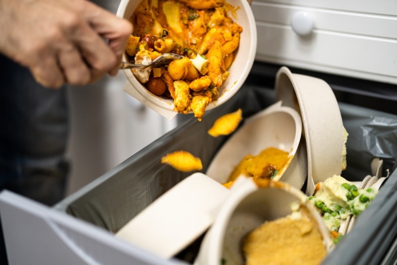 man throwing leftover foods
