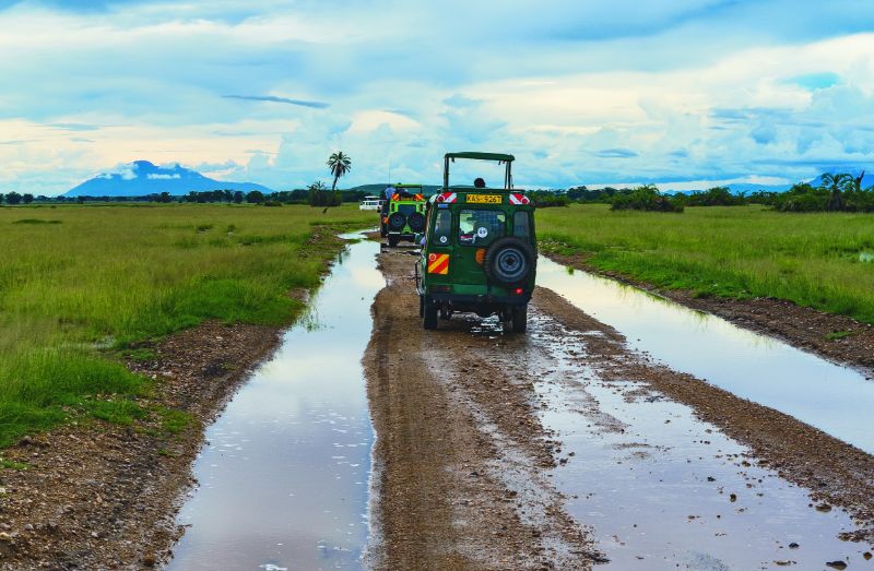 off road vehicles driving down a slightly flooded dirt road