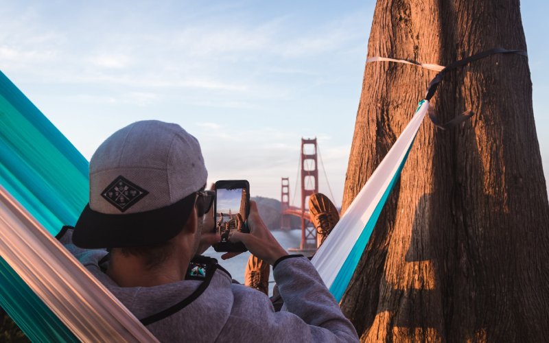 person in hammock hanging from a tree trunk