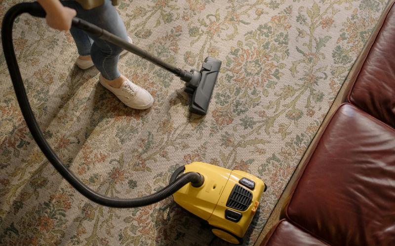 person vacuum cleaning a carpet