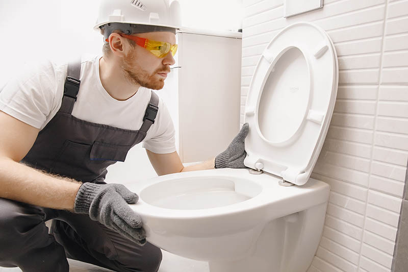 plumber installing toilet bowl