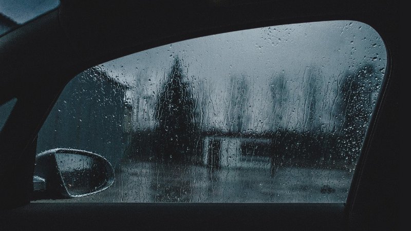 rain-splattered car window and side mirror