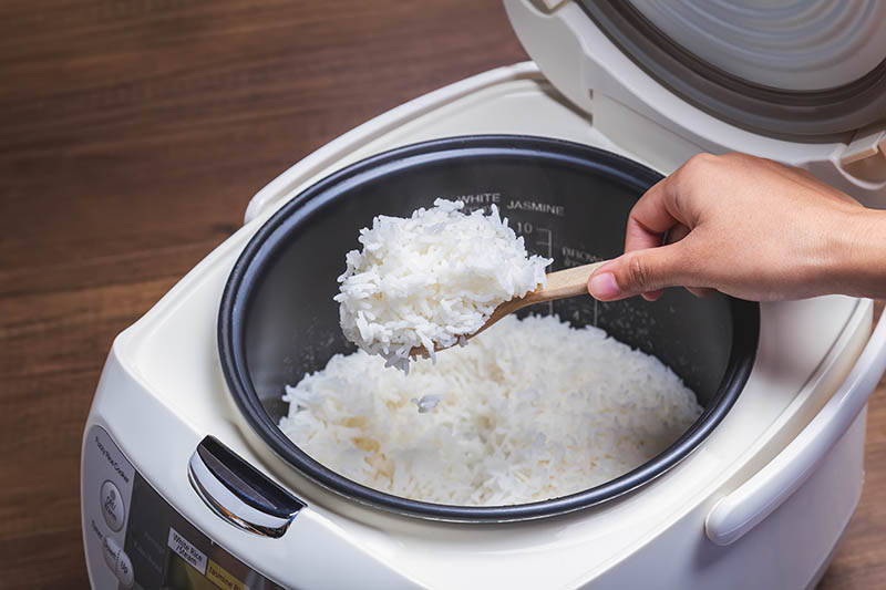 scooping rice from an electric rice cooker