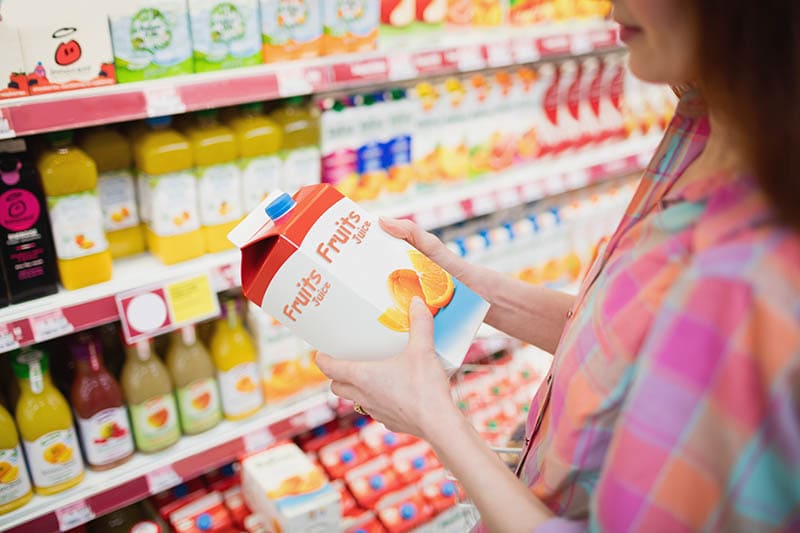 woman buying fruit juice carton