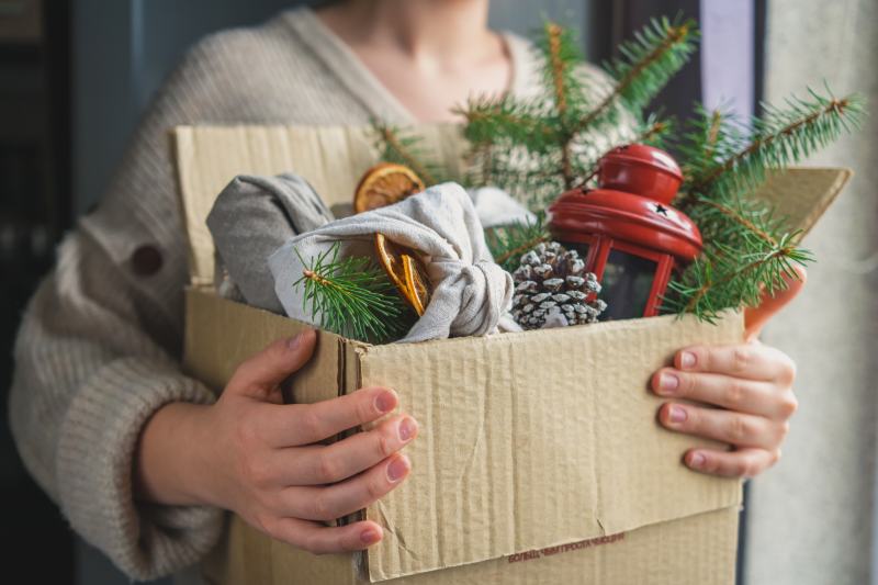 woman holding a box of Christmas decorations in a box